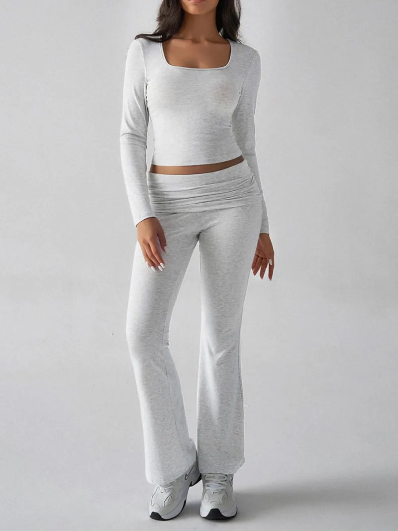Person wearing a gray long-sleeve top and pants on a white background