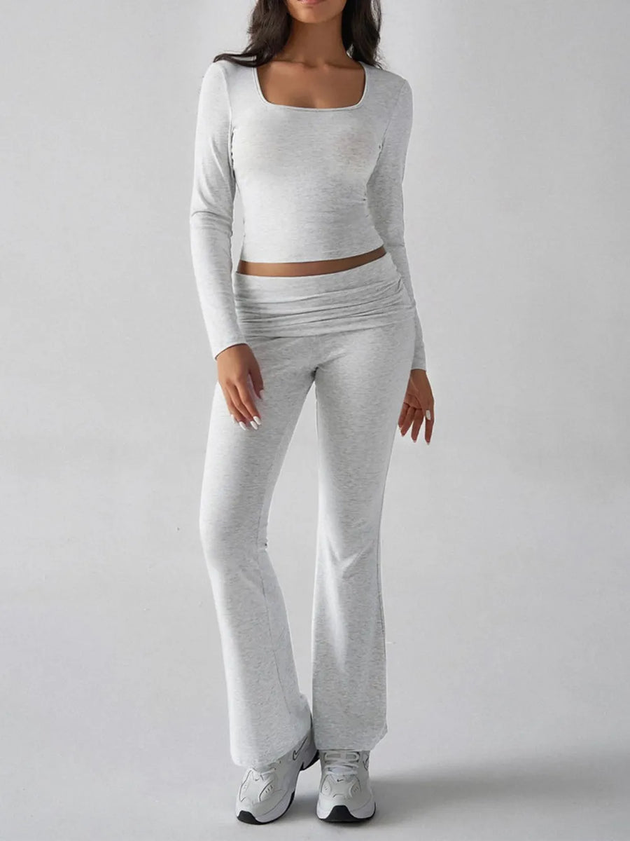 Person wearing a gray long-sleeve top and pants on a white background