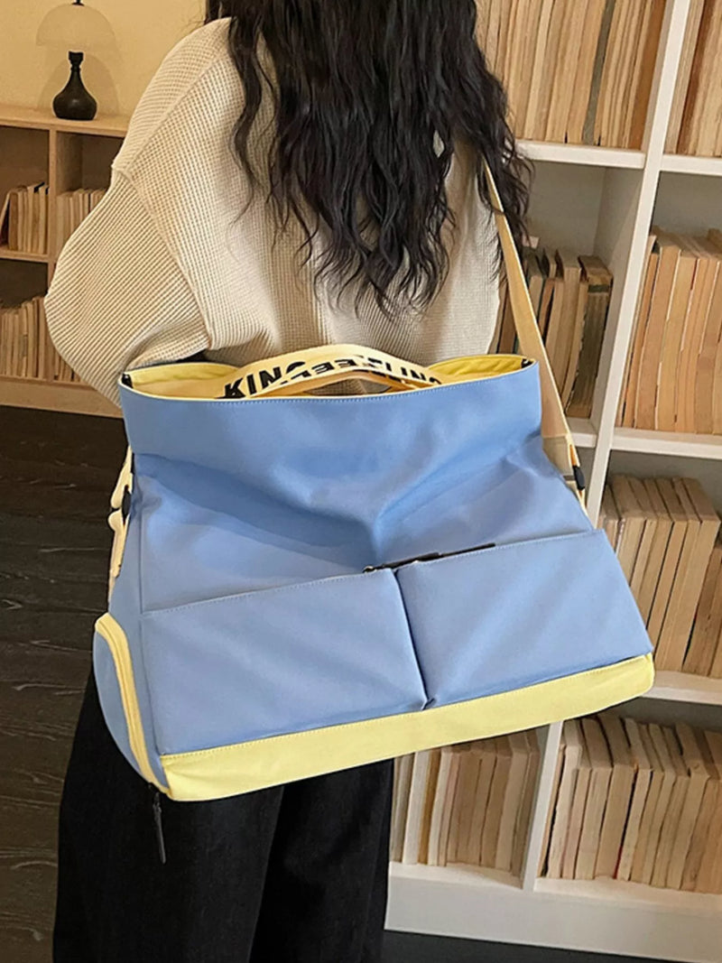 Person holding a blue and yellow bag in a room with bookshelves.