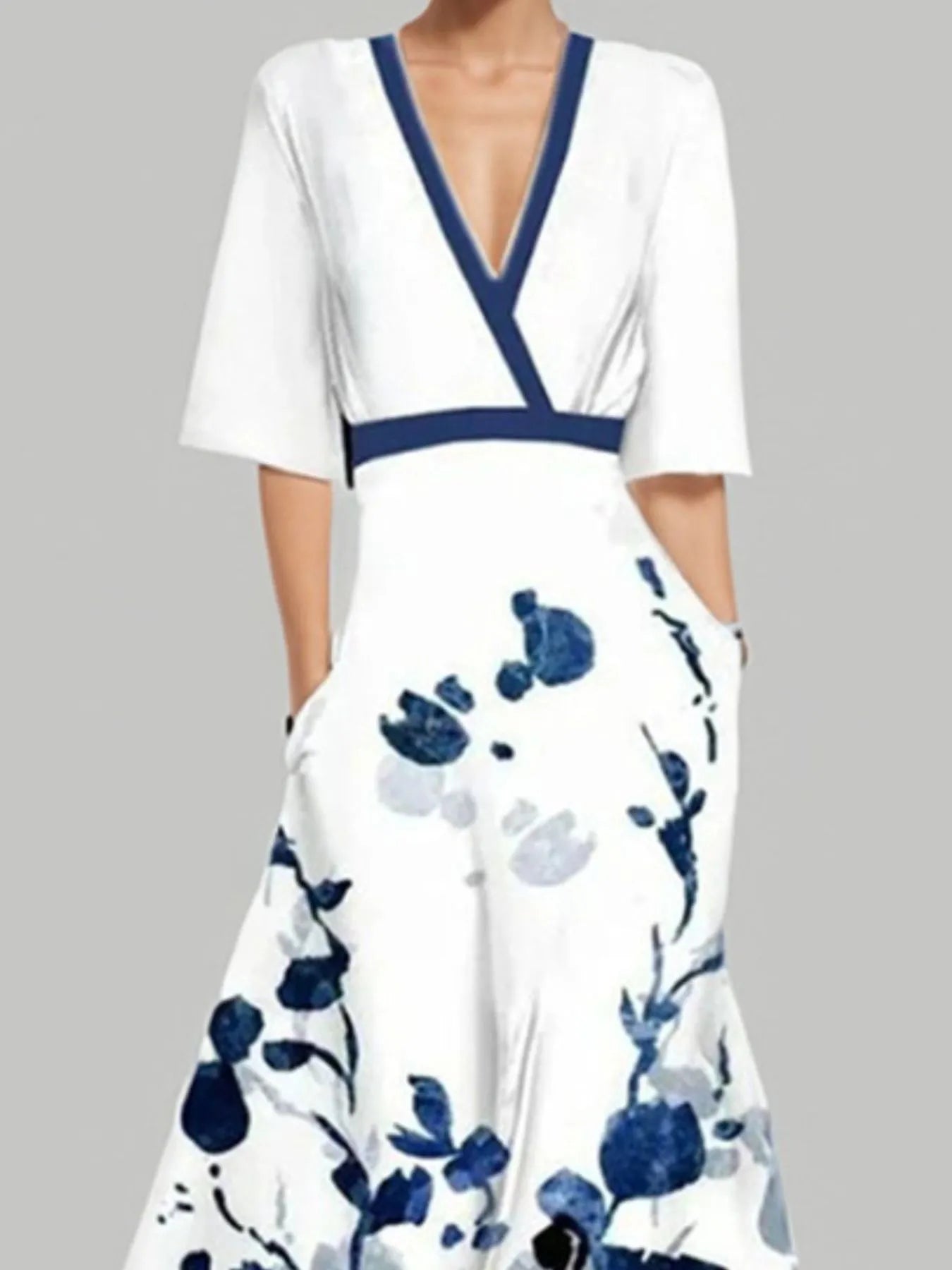 White dress with blue floral pattern and neckline on a gray background