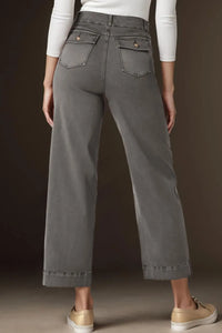 Person wearing gray wide-leg pants with a plain background