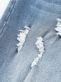 Close-up of a distressed denim fabric with frayed edges.