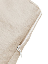 Close-up of a beige fabric pouch with a silver zipper on a white background