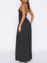 Woman wearing a black polka dot halter neck dress on a white background