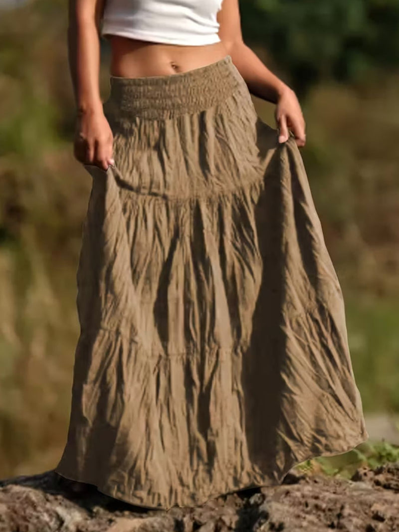 Person wearing a long, tiered skirt outdoors with a blurred natural background