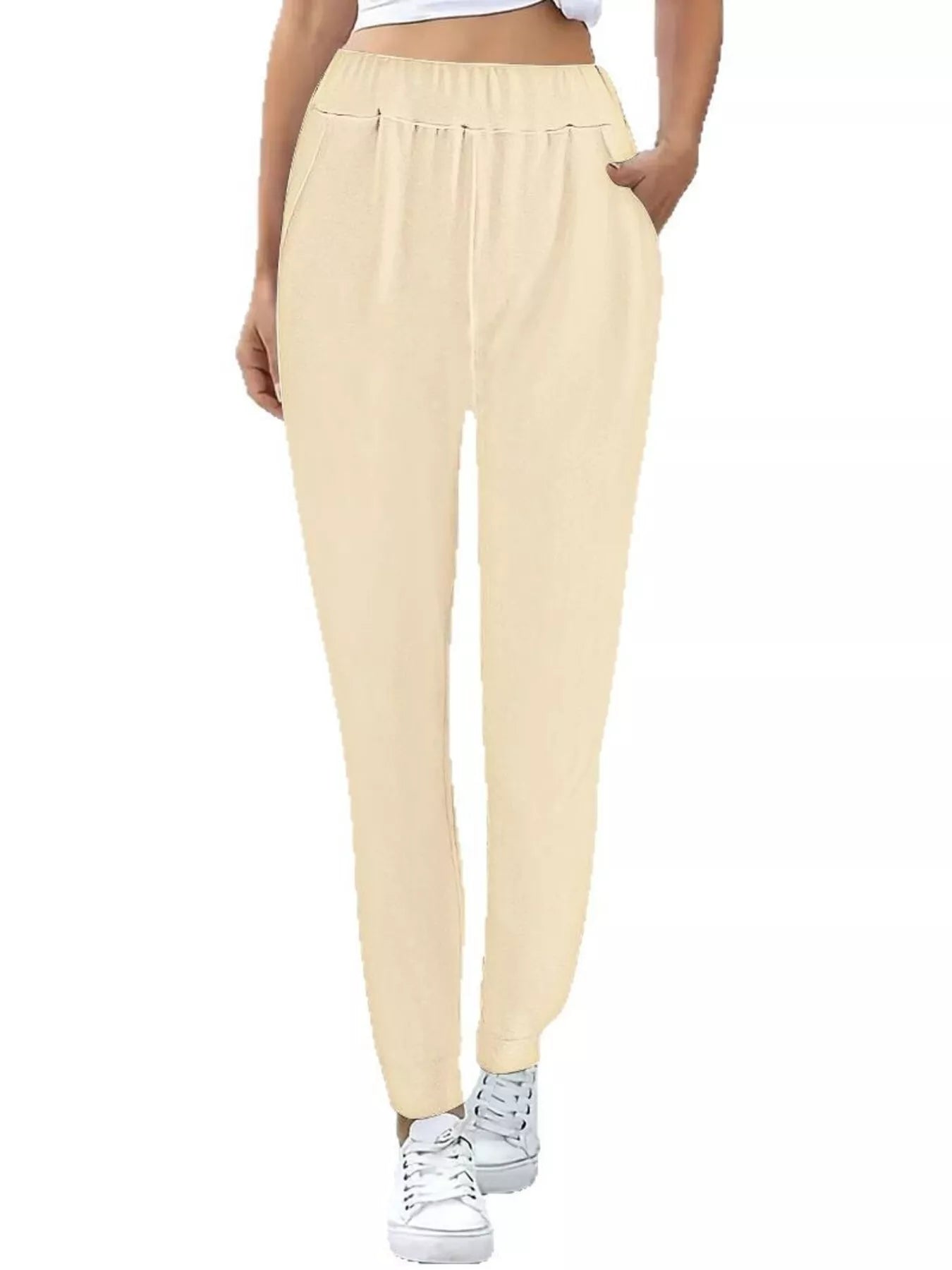 Beige jogger pants worn by a person on a white background