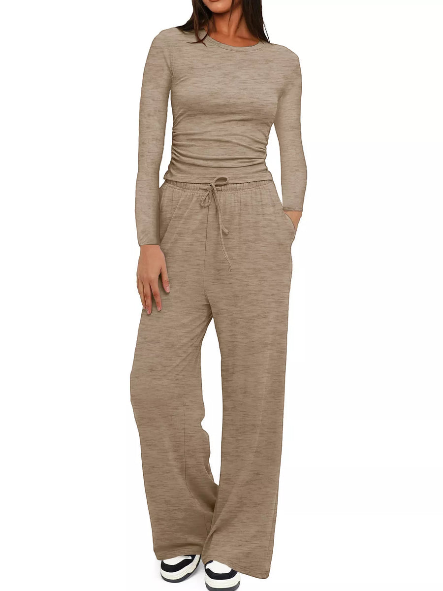 Woman wearing a beige long-sleeve jumpsuit on a white background