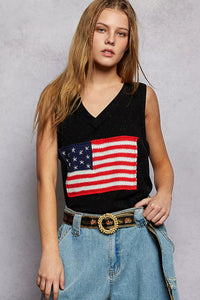 Person wearing a black sleeveless top with an American flag design against a gray background