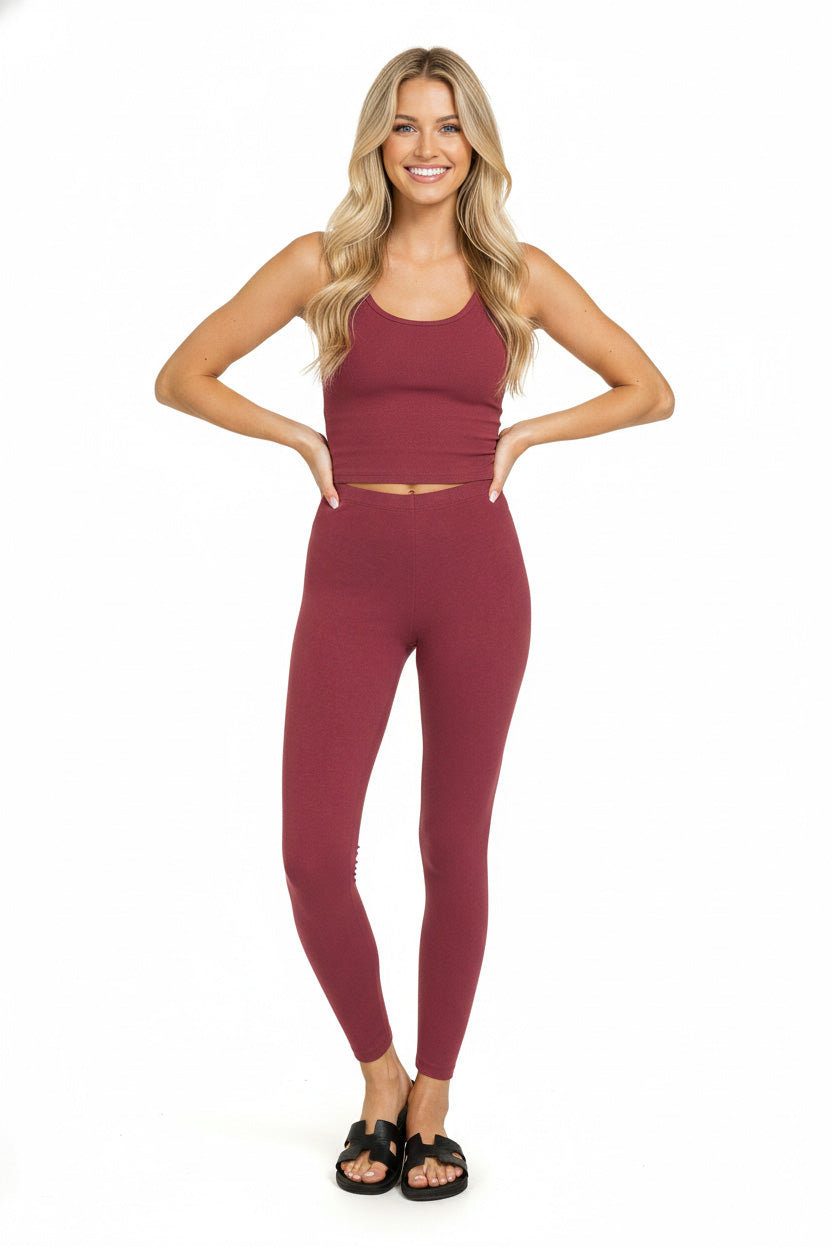 Woman wearing a maroon athletic outfit on a white background
