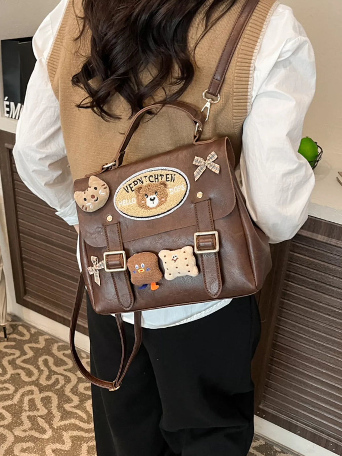 Person wearing a brown backpack with teddy bear designs and 'Venus C' logo.