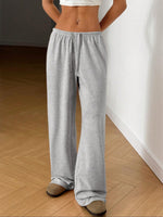 Person wearing gray sweatpants on a wooden floor.