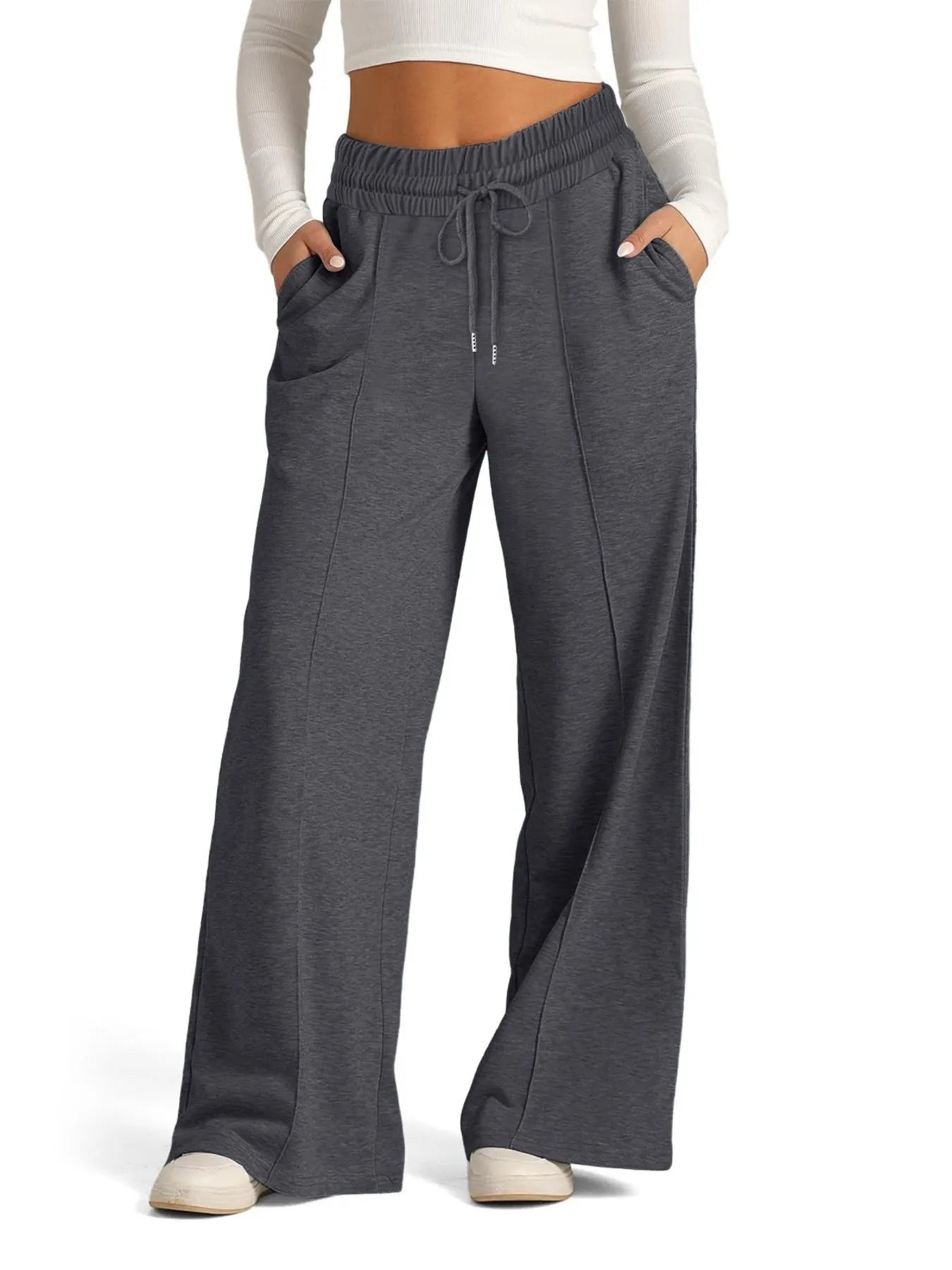 Gray sweatpants worn by a person on a white background