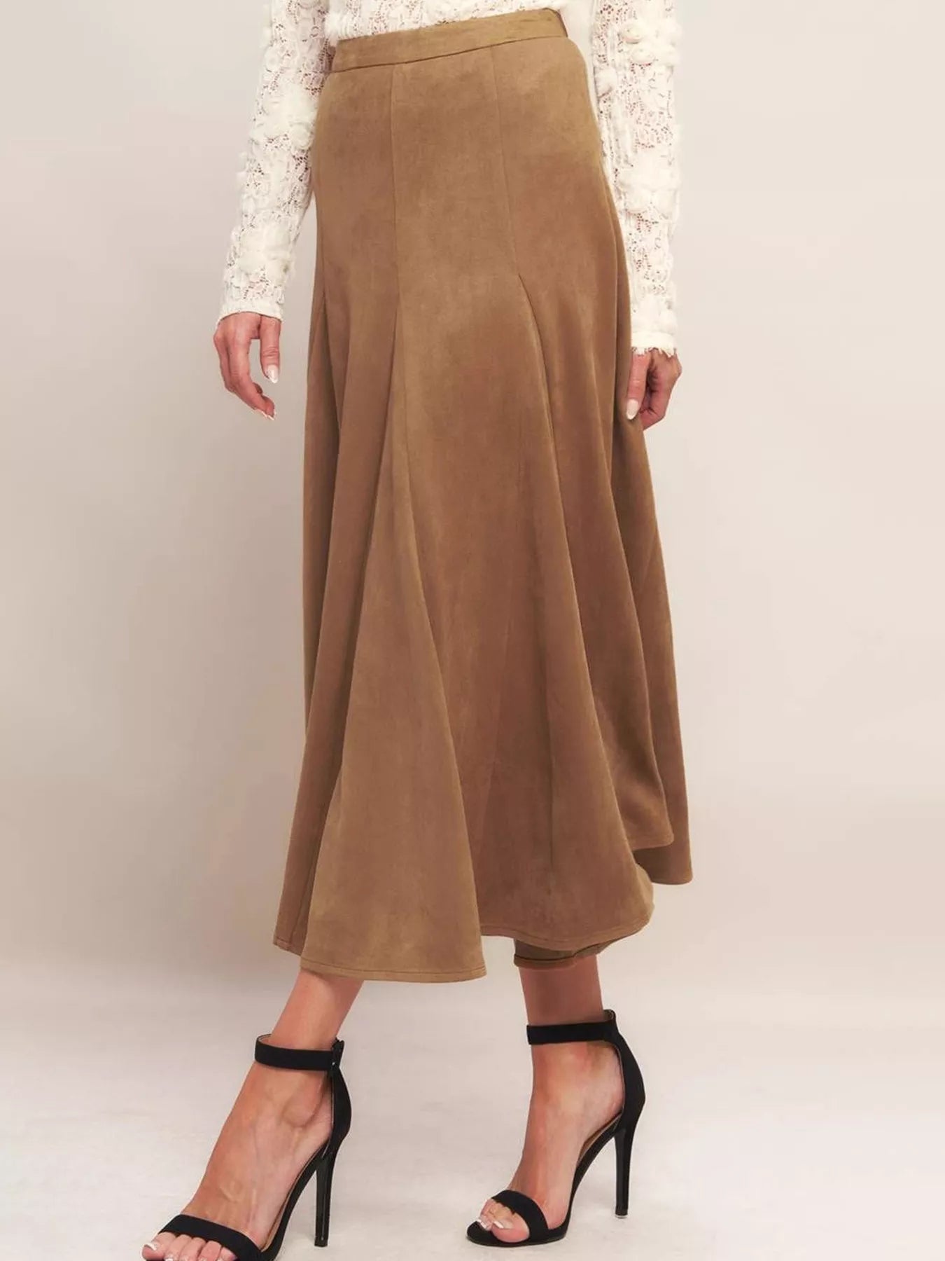 Brown suede skirt worn by a person on a plain background