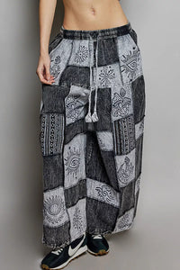 Person wearing a pair of patchwork pants on a plain background