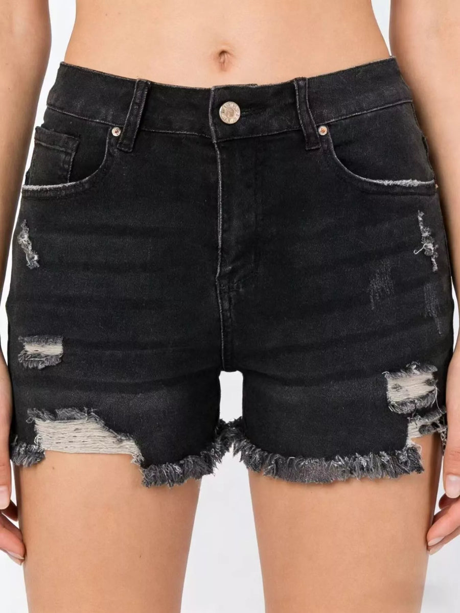Black distressed denim shorts worn by a person on a white background