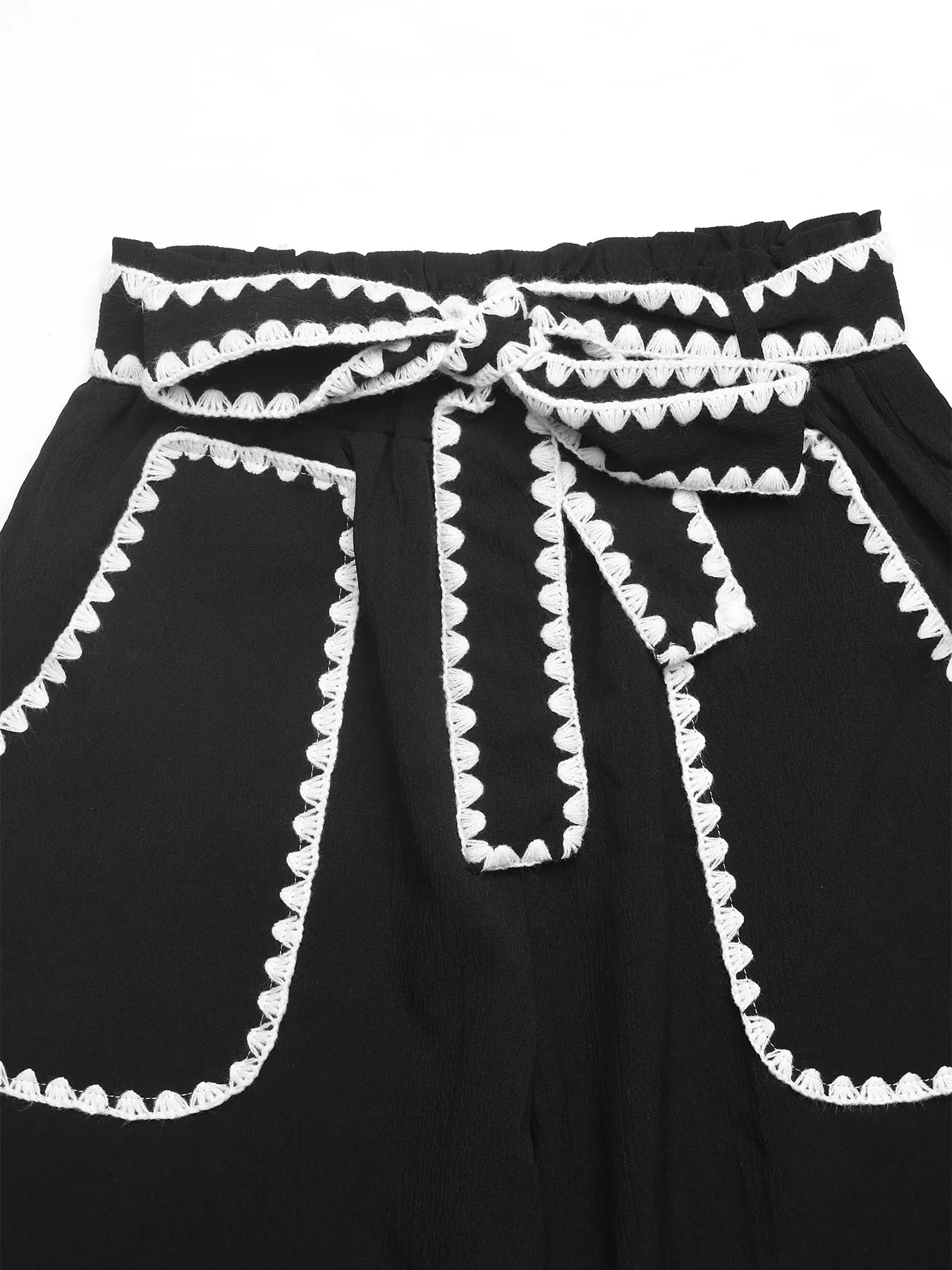Black dress with white trim on a white background