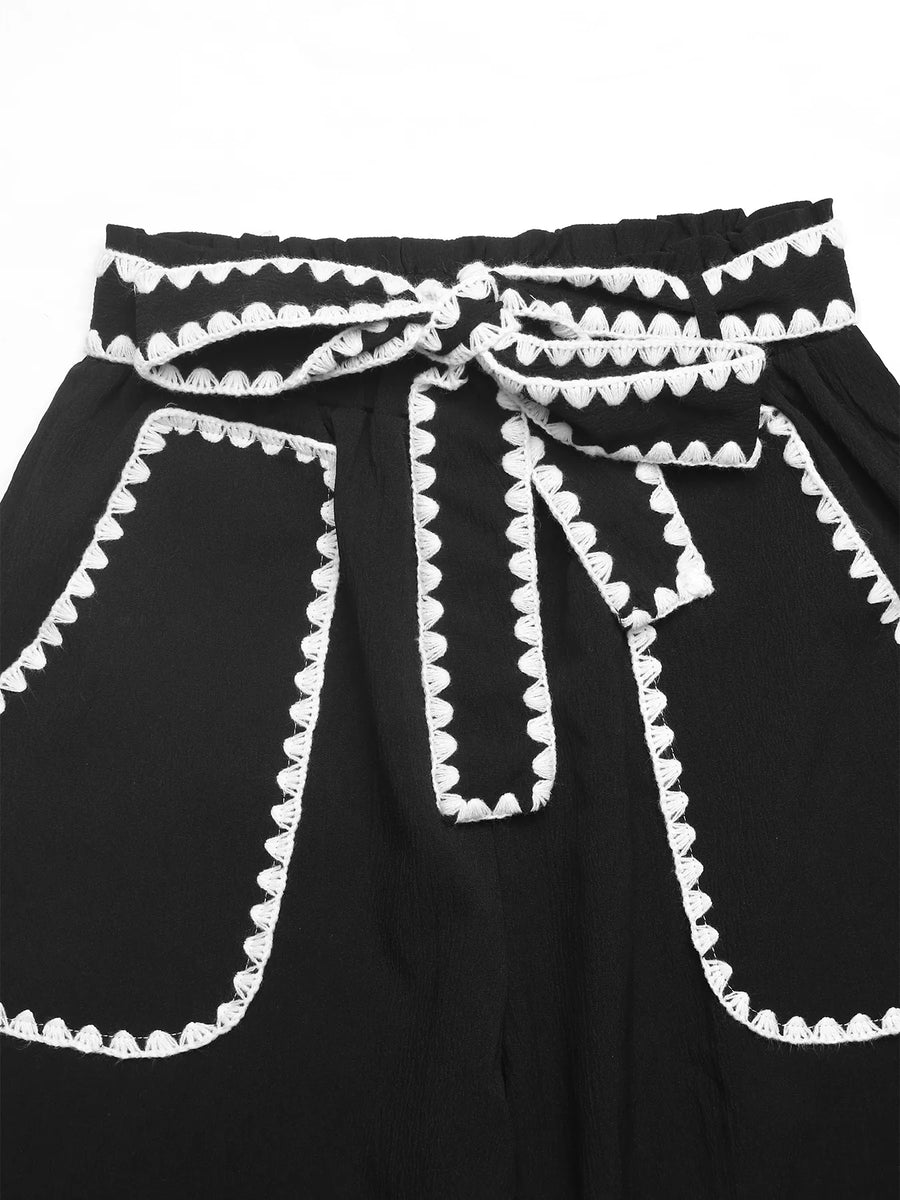 Black dress with white trim on a white background