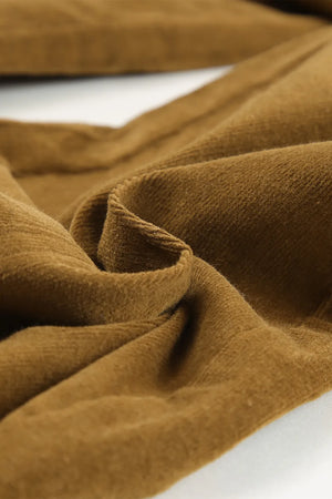Close-up of brown fabric with folds on a white background