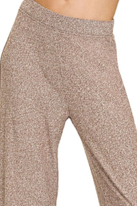 Close-up of beige leggings with a textured pattern on a plain background