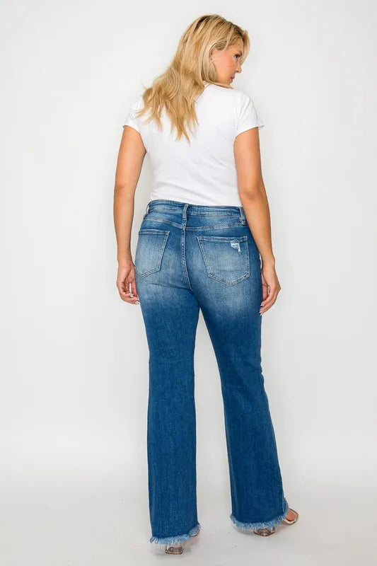 Woman wearing blue jeans and a white top on a plain background