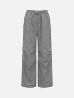 Black and white gingham wide-leg pants with an elastic drawstring waist and large patch pockets, shown on a light gray background.