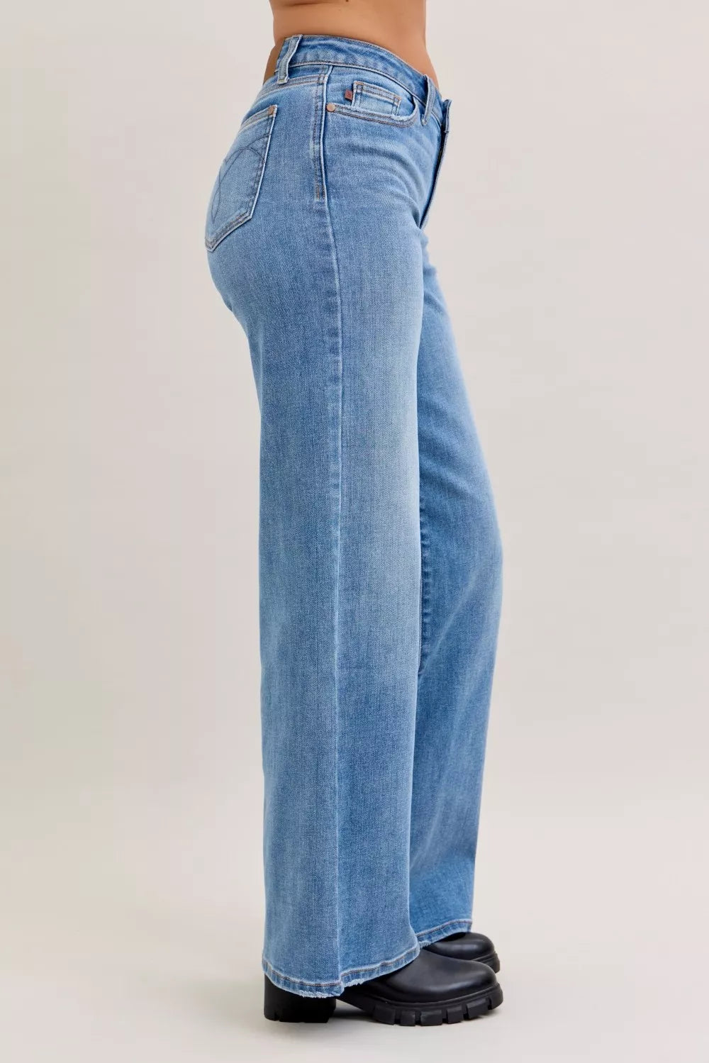 Blue jeans worn by a person on a light gray background