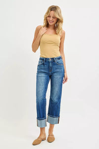 Woman wearing a yellow top and blue jeans on a white background
