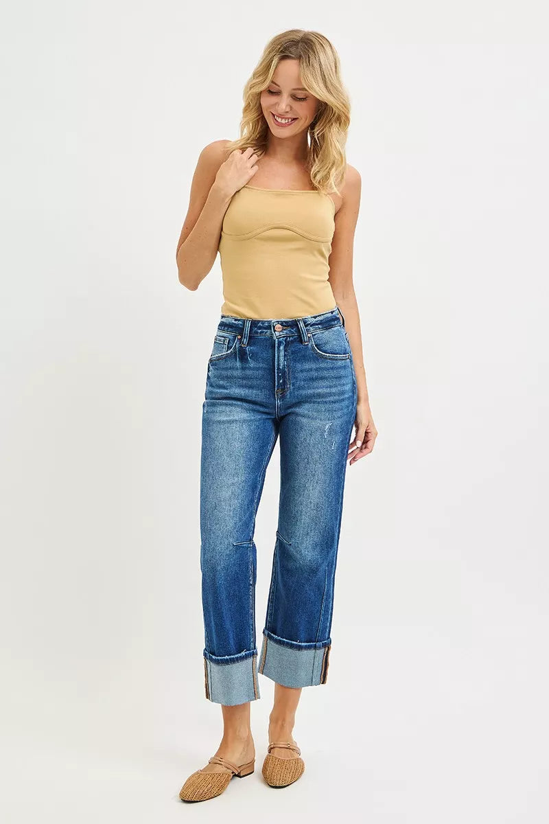 Woman wearing a yellow top and blue jeans on a white background