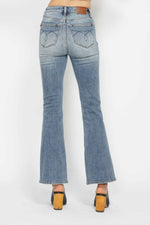 Blue jeans worn by a person on a white background