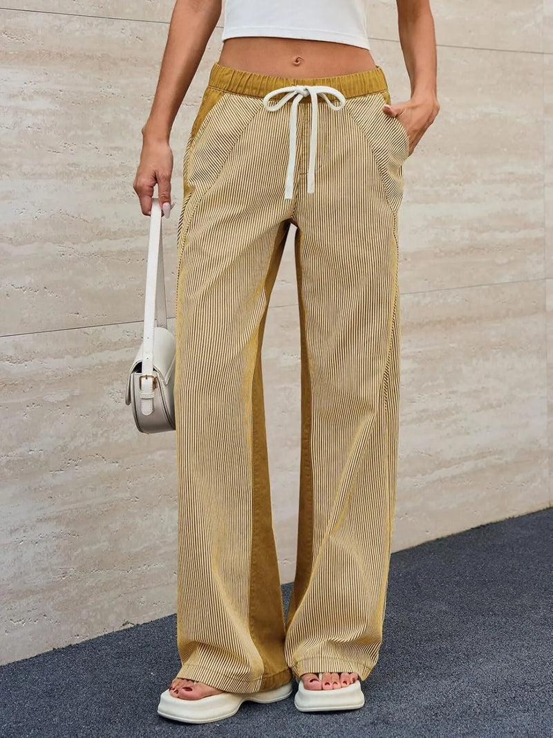 Person wearing beige and yellow striped pants with a white background