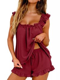 Woman wearing a burgundy romper with ruffled details on a white background