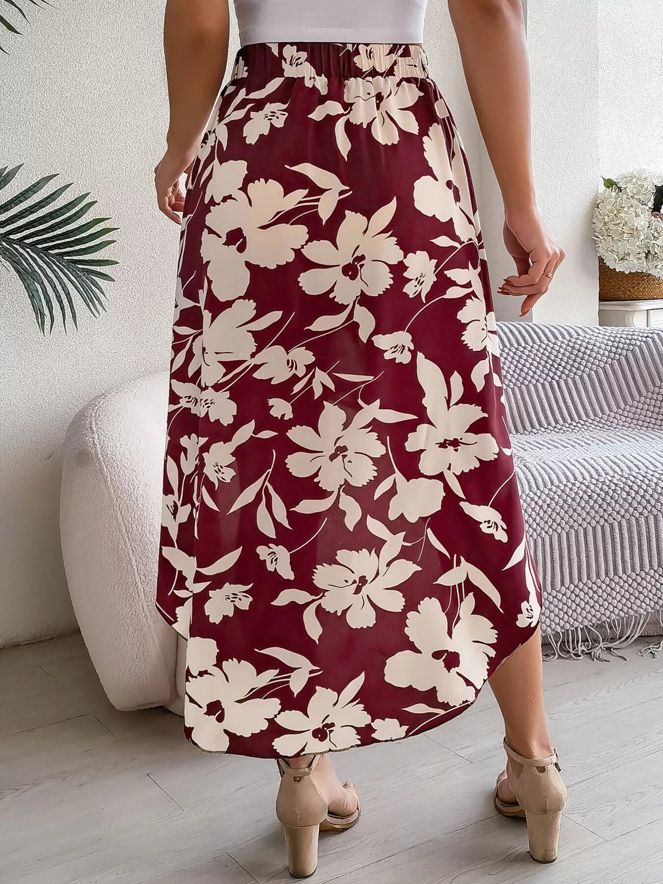 Person wearing a maroon floral skirt in a home setting