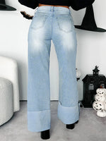 Light blue jeans worn by a person in a room with Halloween decorations.
