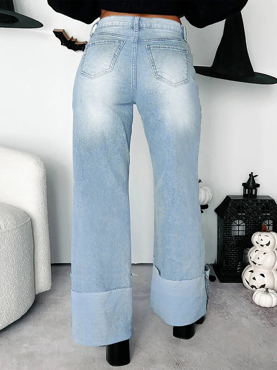 Light blue jeans worn by a person in a room with Halloween decorations.