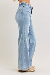 Light blue jeans worn by a person on a plain background