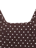 Close-up of a brown dress with white polka dots on a white background