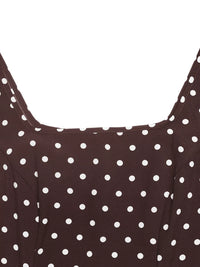 Close-up of a brown dress with white polka dots on a white background