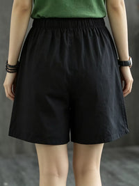Person wearing black shorts and a green top against a neutral background
