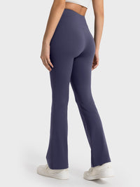 Navy blue flared pants worn by a person on a white background