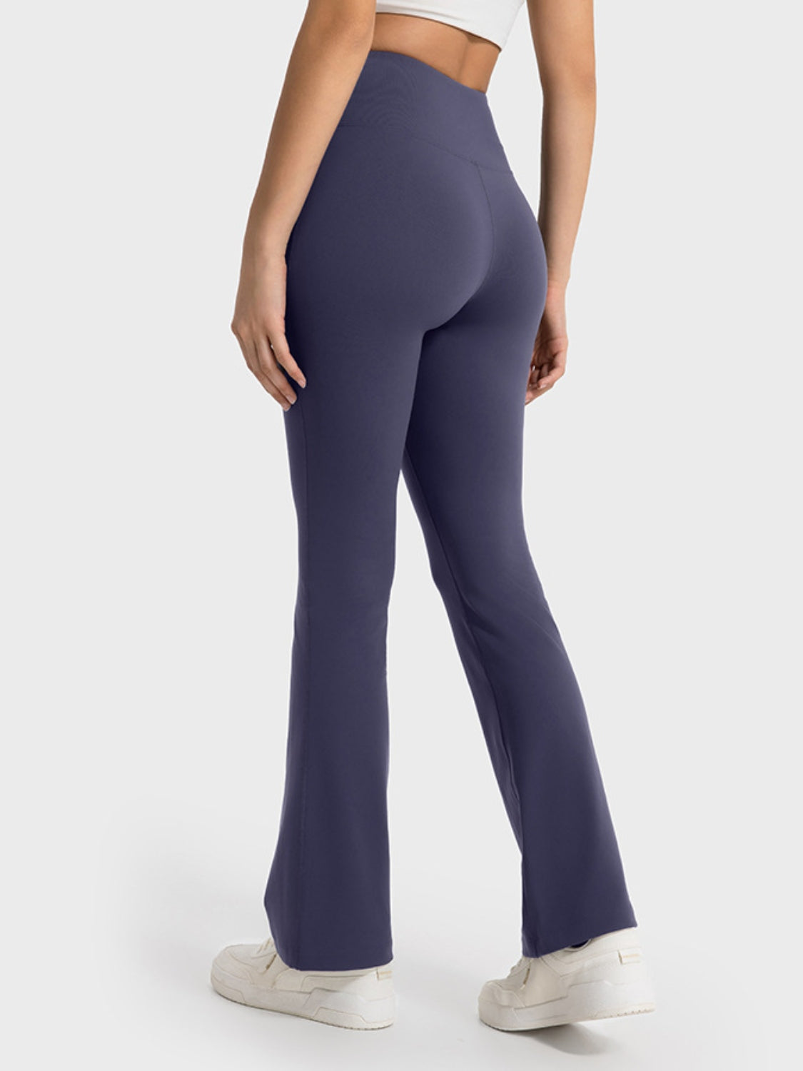 Navy blue flared pants worn by a person on a white background
