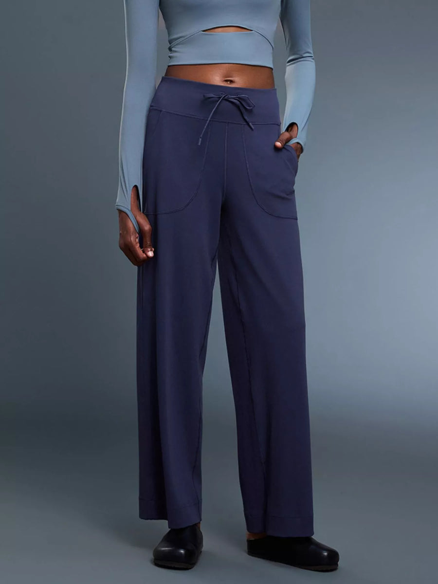 Person wearing a light blue crop top and dark blue pants on a gray background
