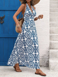 Woman wearing a blue and white patterned dress standing in front of a blue door.
