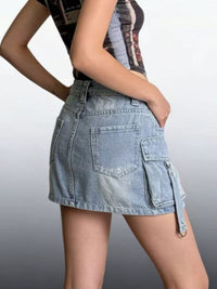 Denim skirt with cargo pockets worn by a person on a plain background