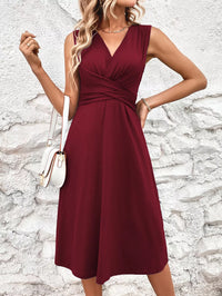 Woman wearing a burgundy dress against a textured white wall