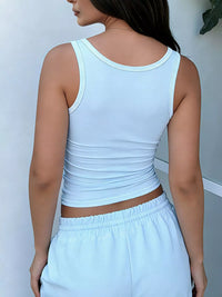 Person wearing a light blue tank top and pants against a white background