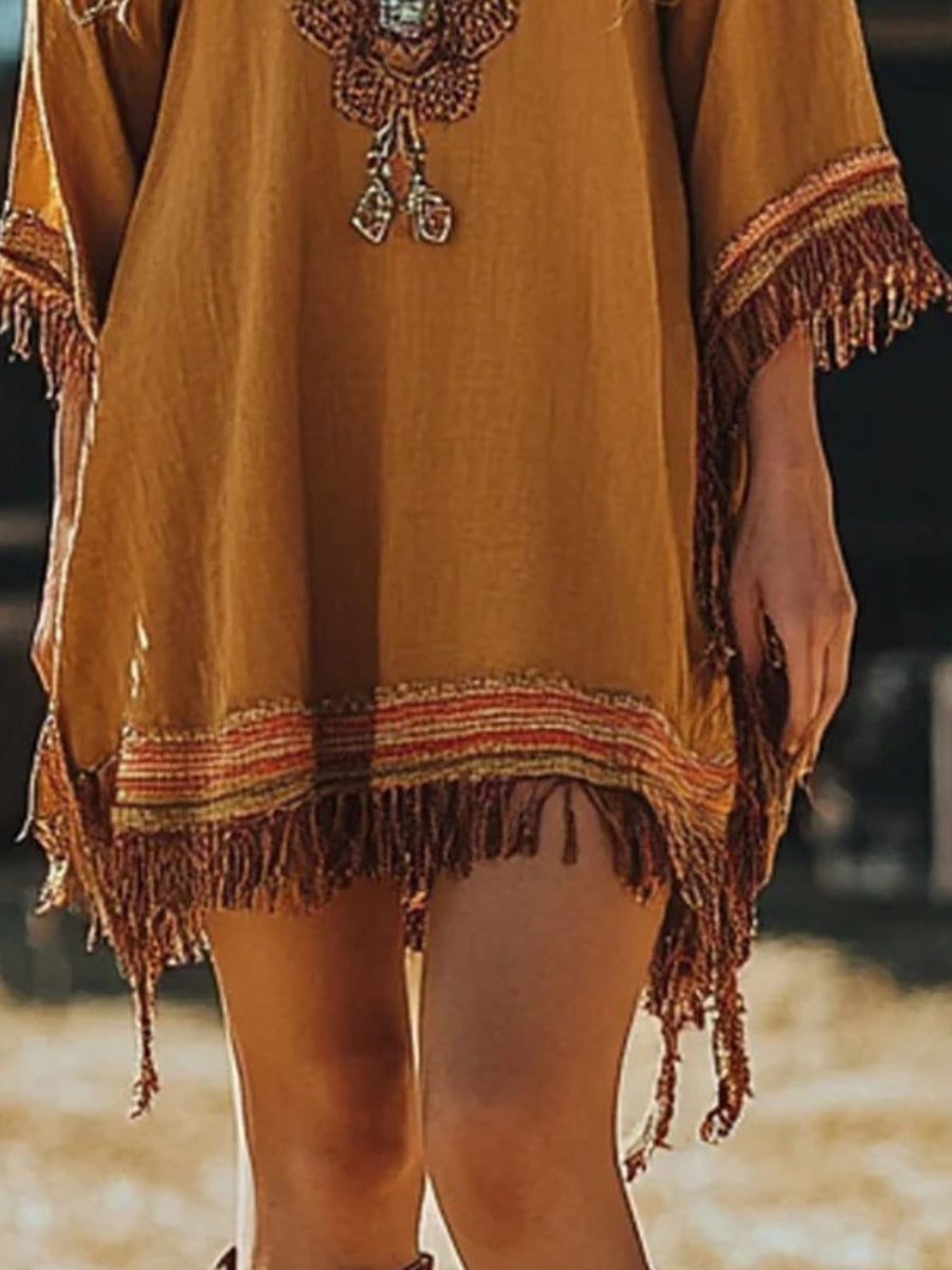 Mustard yellow dress with fringe details on a blurred background
