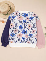 Floral patterned sweater with colorful sleeves on a beige background