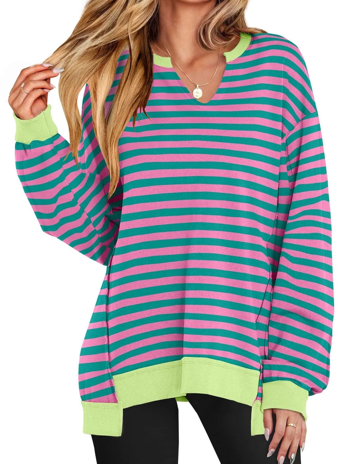 Woman wearing a colorful striped sweater with green, pink, and blue horizontal stripes on a white background.
