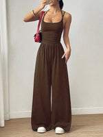 Woman wearing a brown jumpsuit with a plain background