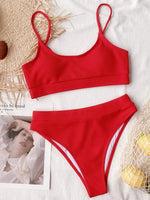 Red bikini set on a white surface with a blurred background